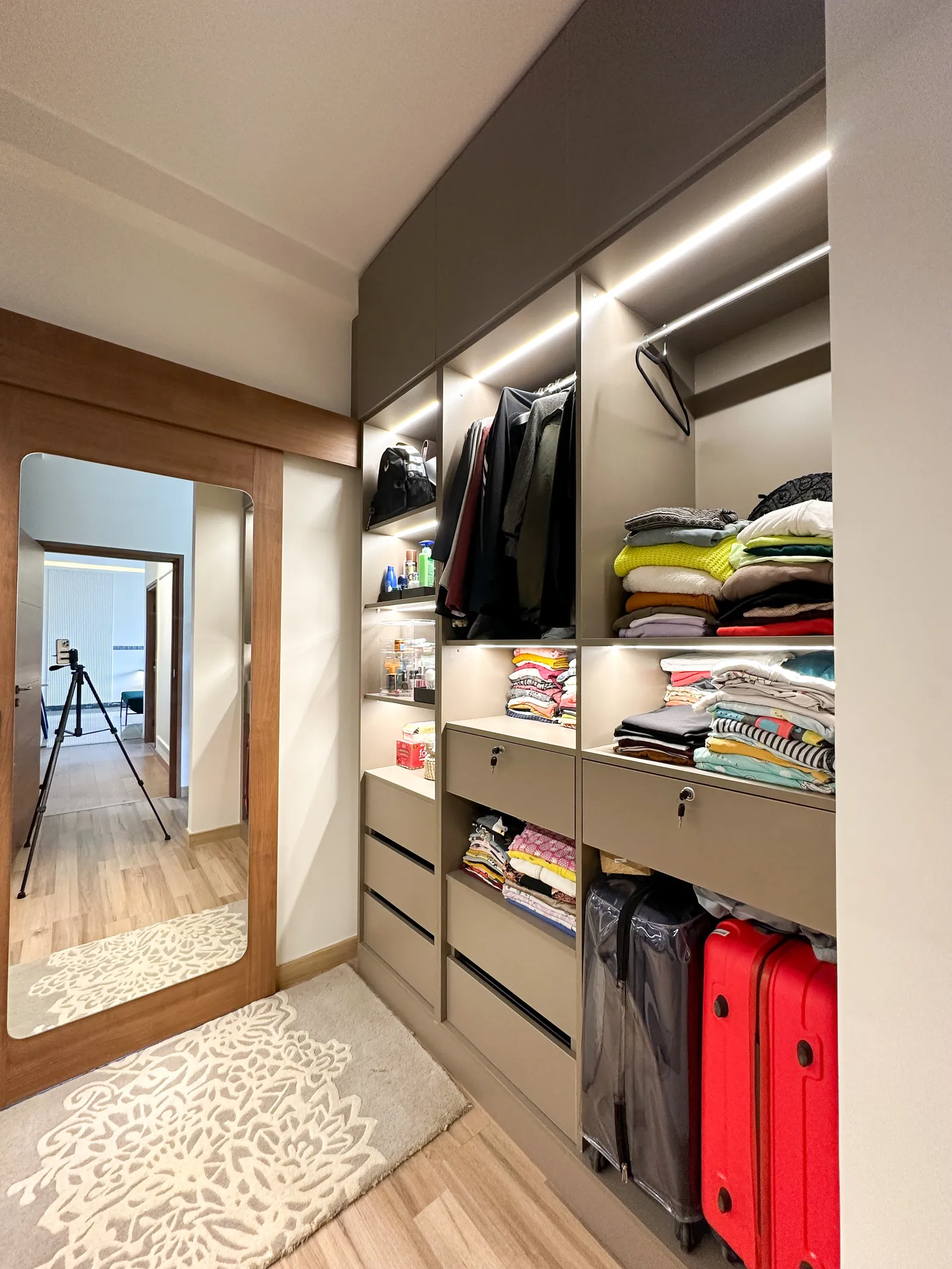 Walk-in wardrobe with lit shelves and full-length mirror — Somani's Residence